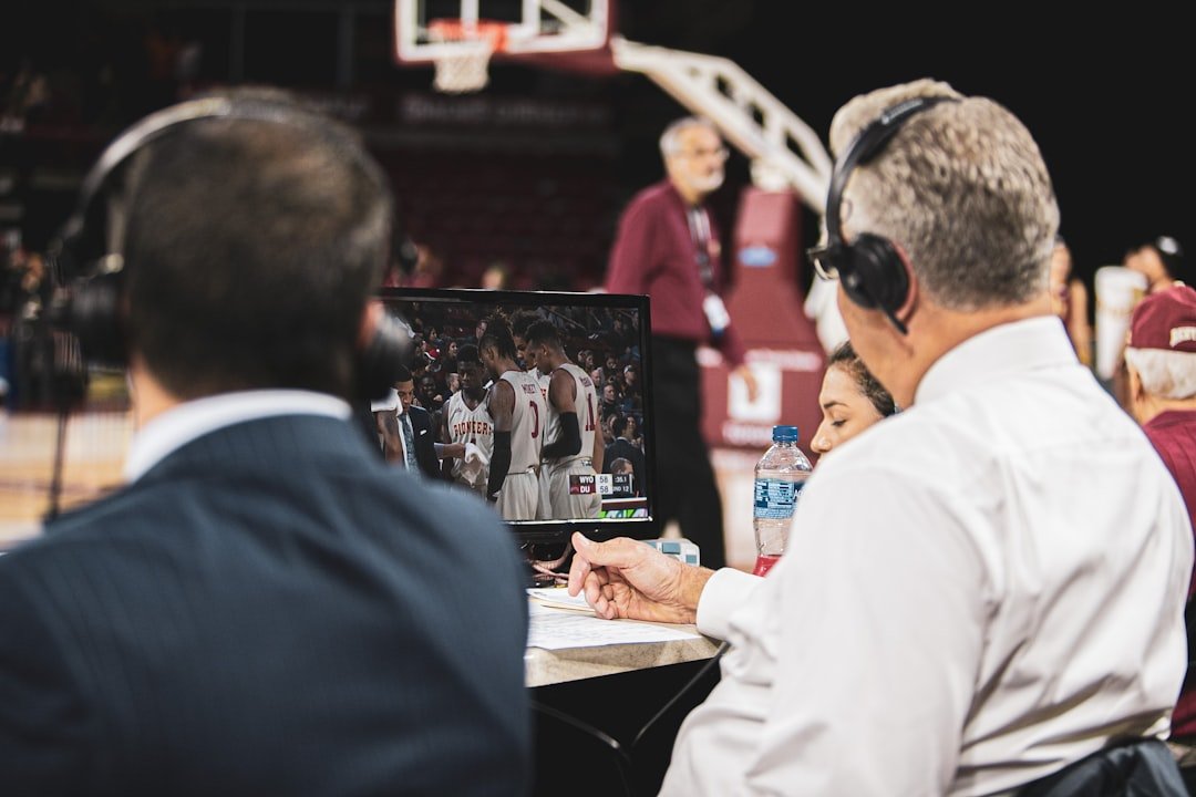 NBA coaching staff analyzing game footage on multiple screens with player performance data overlays